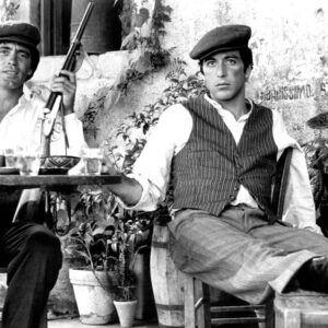 Portrait sombre et intense d'Al Pacino dans le rôle de Michael Corleone dans le film Le Parrain, portant un costume cravate, regardant hors champ.