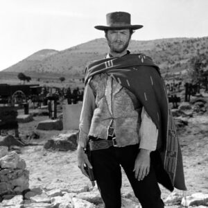 Affiche Eastwood Western Solo : Portrait en noir et blanc de Clint Eastwood debout dans un cimetière, portant son poncho iconique et un chapeau de cowboy, scène du film Le Bon, la Brute et le Truand.