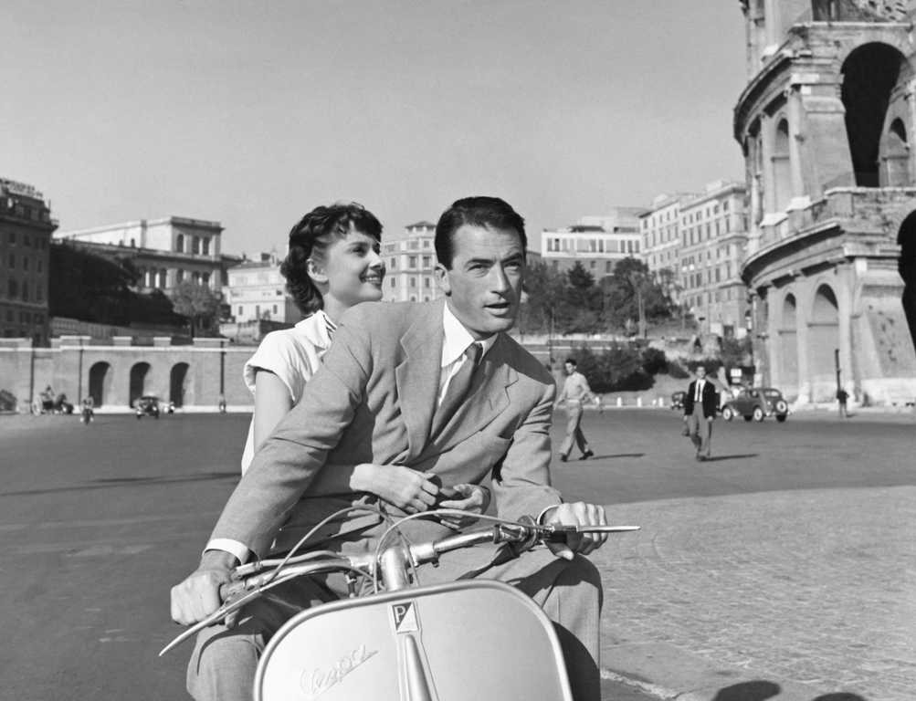 BRHA107 7144110 Photographie en noir et blanc d'Audrey Hepburn et Gregory Peck sur un scooter Vespa devant le Colisée à Rome, tirée du film Vacances Romaines.