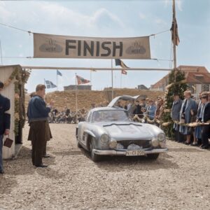 Mercedes 300 SL Gullwing (1957) : Affiche Arrivée de Course | Fuzars Photographie historique colorisée de 1957 montrant une Mercedes-Benz 300 SL argentée aux portes "papillon" ouvertes, franchissant la ligne d'arrivée d'une épreuve automobile devant une foule.