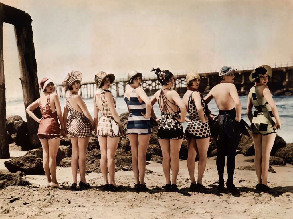 Les Baigneuses (1920) : Charme & Années Folles | Fuzars Photographie vintage colorisée de 1920 montrant huit femmes en maillots de bain rétro alignées sur la plage et regardant par-dessus leur épaule.