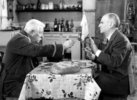 Affiche en noir et blanc du film Le Tatoué avec Louis de Funès et Jean Gabin attablés dans une cuisine rustique