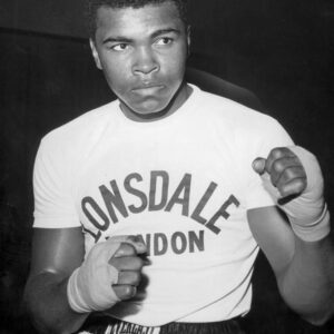 Affiche Mohamed Ali : photographie vintage en noir et blanc de 1963 montrant Cassius Clay (Mohamed Ali) portant des gants de boxe, s'appuyant sur les cordes d'un ring dans une pose pensive.