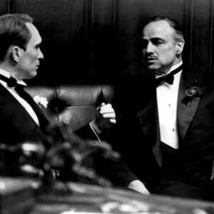Affiche Brando/Duvall - Parrain : Photo noir et blanc du film Le Parrain (1972) montrant Marlon Brando (Vito Corleone) et Robert Duvall (Tom Hagen) en smoking, discutant avec intensité dans un bureau sombre.
