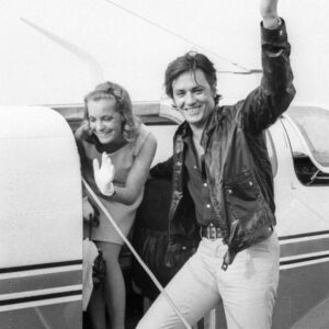 BRRS105 - 1657531 Affiche Delon Romy Schneider : photographie vintage en noir et blanc de 1968 montrant Alain Delon et Romy Schneider souriants, descendant d'un petit avion de tourisme.