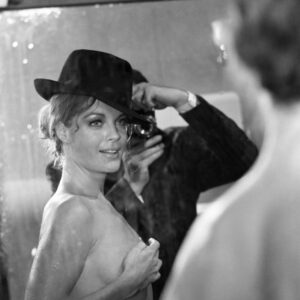 "Affiche noir et blanc de Romy Schneider topless portant un chapeau noir, regardant par-dessus son épaule avec un sourire, issue du film Max et les Ferrailleurs."