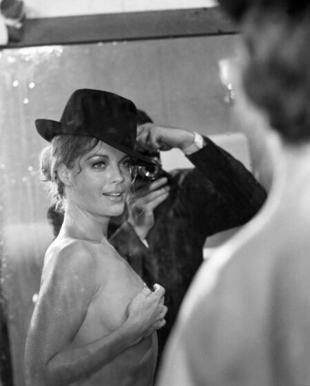 "Affiche noir et blanc de Romy Schneider topless portant un chapeau noir, regardant par-dessus son épaule avec un sourire, issue du film Max et les Ferrailleurs."