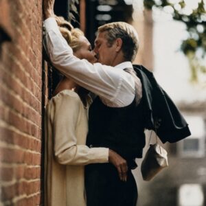 Photographie noir et blanc de Steve McQueen et Faye Dunaway s'embrassant passionnément contre un mur de briques, scène du film L'Affaire Thomas Crown.