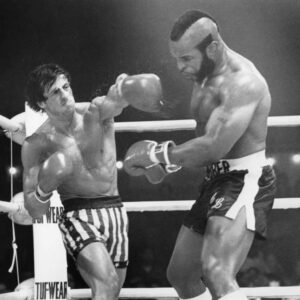 SYS07 Photographie en noir et blanc de Sylvester Stallone dans son rôle emblématique de Rocky Balboa pour le film Rocky III. L'acteur est représenté torse nu, en pleine forme physique, portant ses gants de boxe et prêt au combat sur le ring.