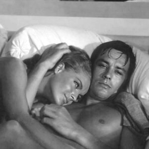 Photographie noir et blanc d'Alain Delon et Romy Schneider intimement enlacés dans le film La Piscine (1969).