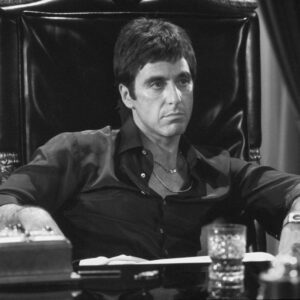 BRAP102NB - 4058409 Affiche Scarface Al Pacino : photographie d'art en noir et blanc de 1983 montrant Al Pacino dans le rôle de Tony Montana assis dans un grand fauteuil en cuir noir derrière son bureau, regard intense.