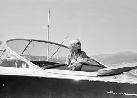 Affiche Brigitte Bardot Riva : photographie vintage en noir et blanc de 1965 montrant Brigitte Bardot pensive à bord d'un bateau Riva Aquarama dans la baie de Saint-Tropez.