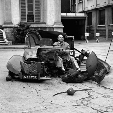 Affiche Bourvil Le Corniaud : photographie culte en noir et blanc de 1965 montrant Bourvil assis dans les restes de sa 2CV disloquée après la scène de l'accident.