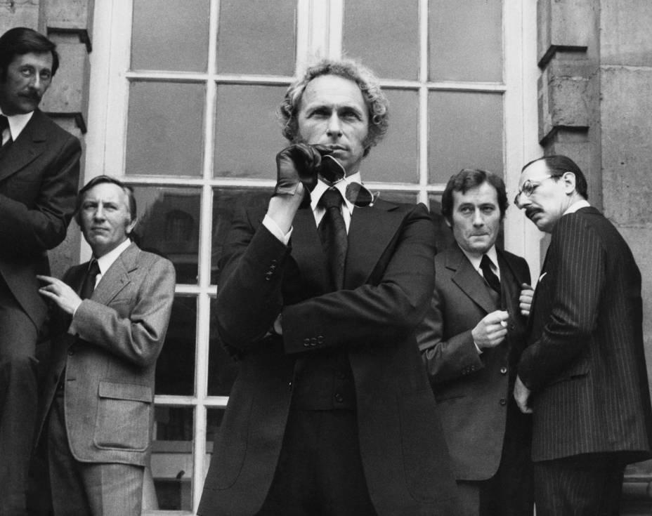BRPERI100 -1676948 Affiche Le Retour du Grand Blond : photographie d'art en noir et blanc de 1974 montrant Pierre Richard avec des lunettes de soleil, entouré de Jean Rochefort, Michel Duchaussoy et Paul Le Person dans une scène culte d'espionnage.