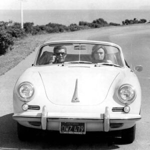 Affiche McQueen Porsche Bullitt : photographie vintage en noir et blanc de 1968 montrant Steve McQueen et Jacqueline Bisset dans une Porsche 356 Speedster blanche sur une route côtière.