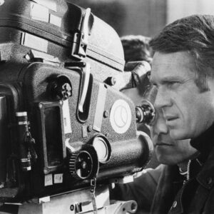 Affiche Mcqueen Bullitt : photographie d'art en noir et blanc de 1968 montrant Steve McQueen de profil derrière une caméra de cinéma sur le tournage du film Bullitt à San Francisco.