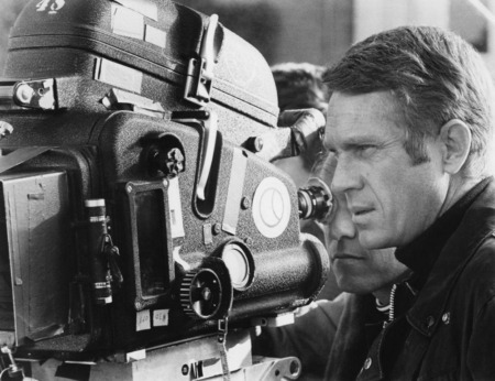Affiche Mcqueen Bullitt : photographie d'art en noir et blanc de 1968 montrant Steve McQueen de profil derrière une caméra de cinéma sur le tournage du film Bullitt à San Francisco.