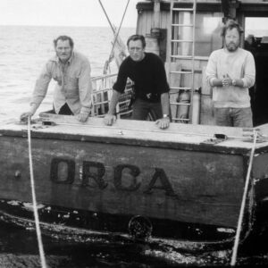 Affiche Les Dents de la mer : photographie d'art en noir et blanc de 1975 montrant Robert Shaw, Roy Scheider et Richard Dreyfuss sur le pont arrière du bateau Orca.